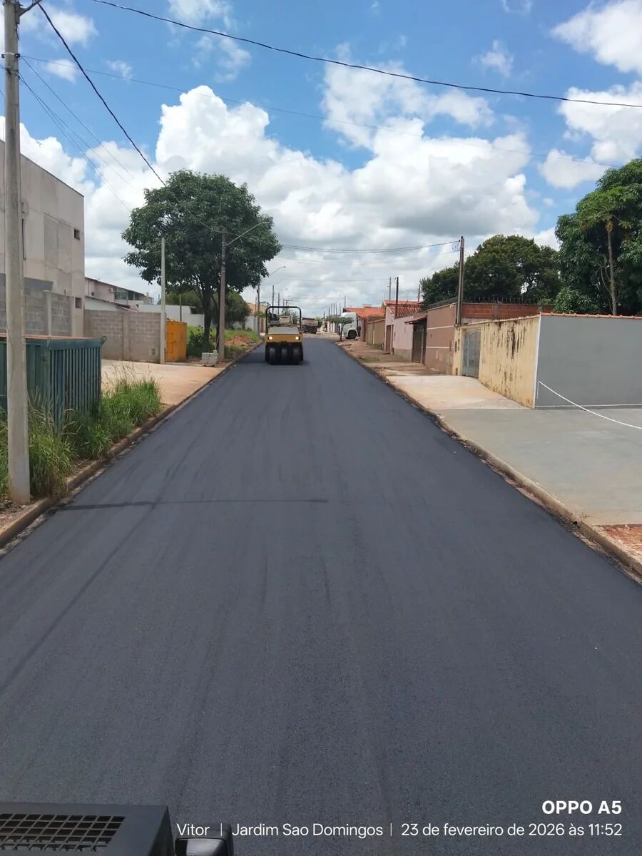 Rolo compactador sobre asfalto novo em rua residencial