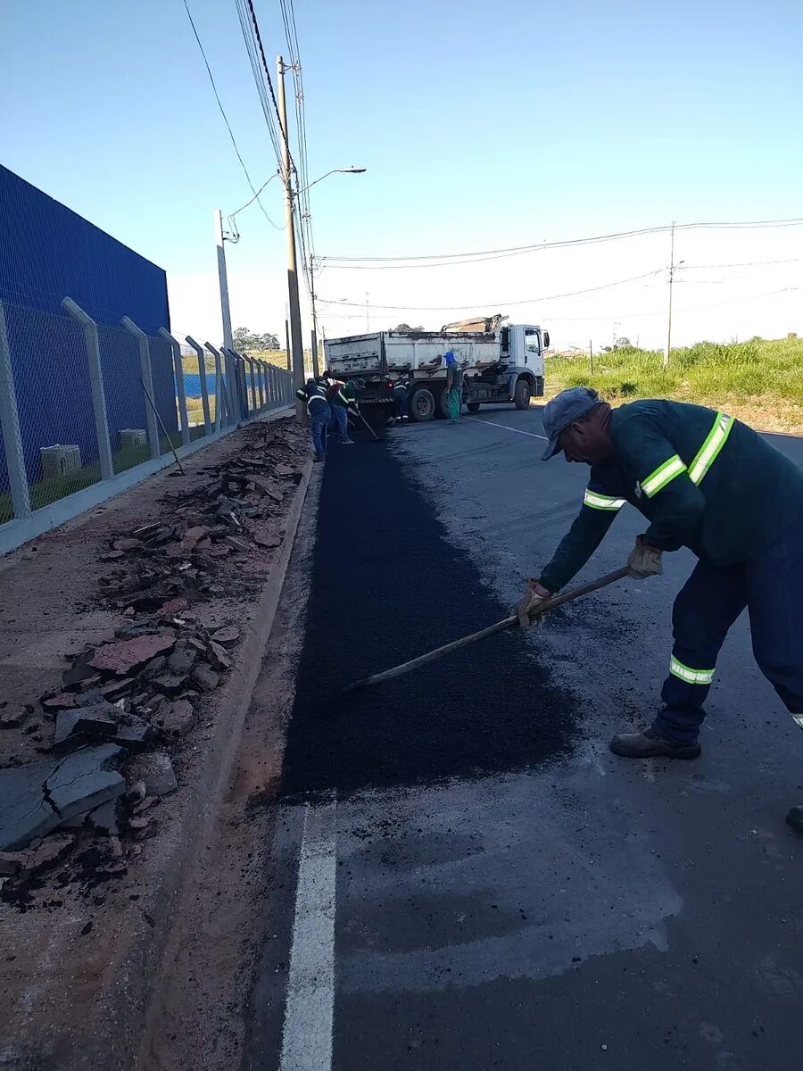 Equipe com pás em operação de recapeamento asfáltico