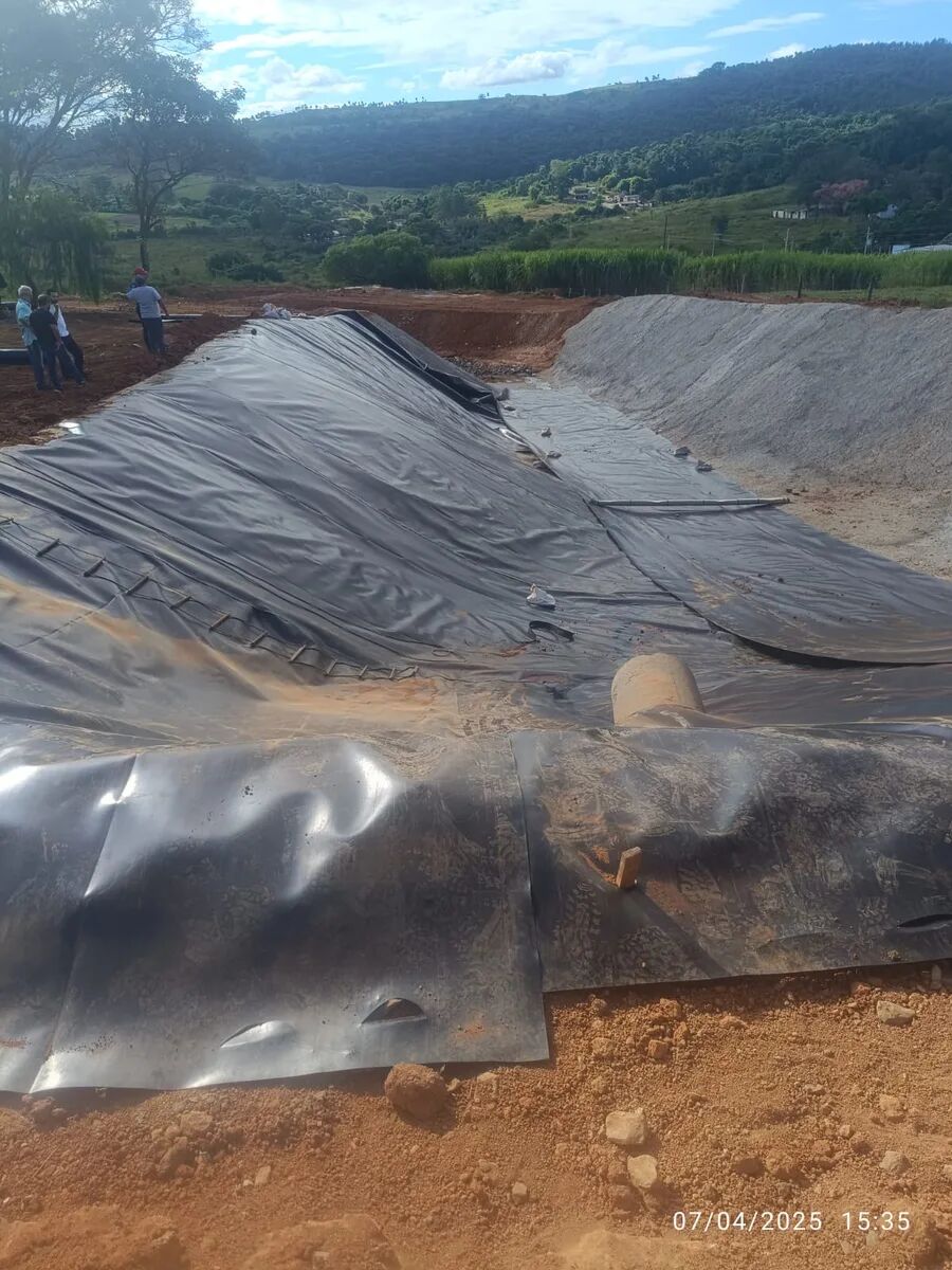 Reservatório com manta geotêxtil instalada em área rural